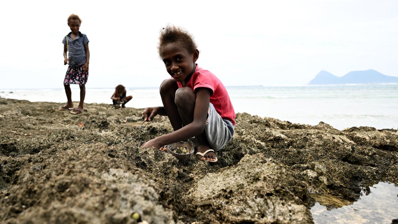 Children collect sea snails on Nguna Island, Vanuatu