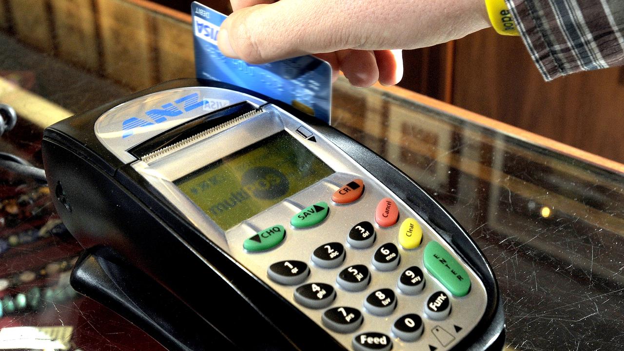 A debit card being swiped through a payment machine