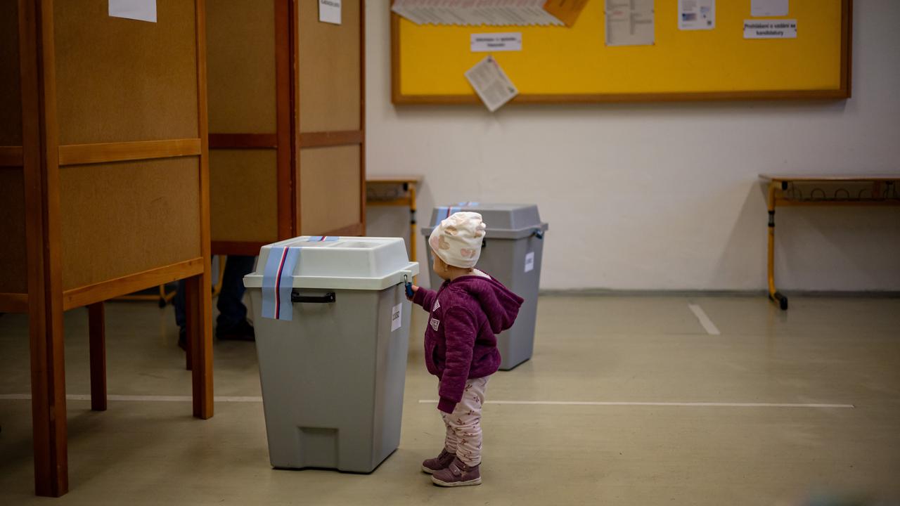 A child plays with the lock on a ballot box
