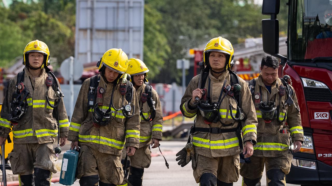 Firefighters walk near the scene of the deadly fire