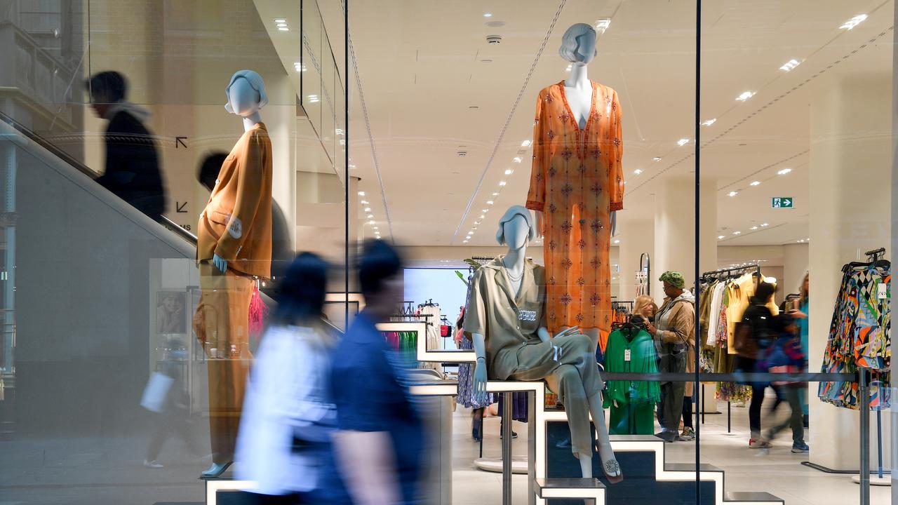 Pedestrians walk past a shop in Sydney