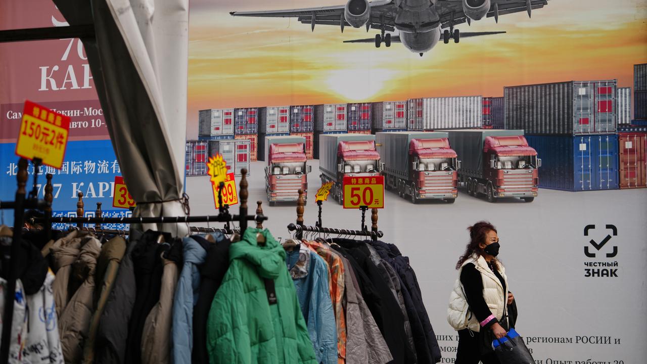 A woman walks by a poster advertise a logistic company