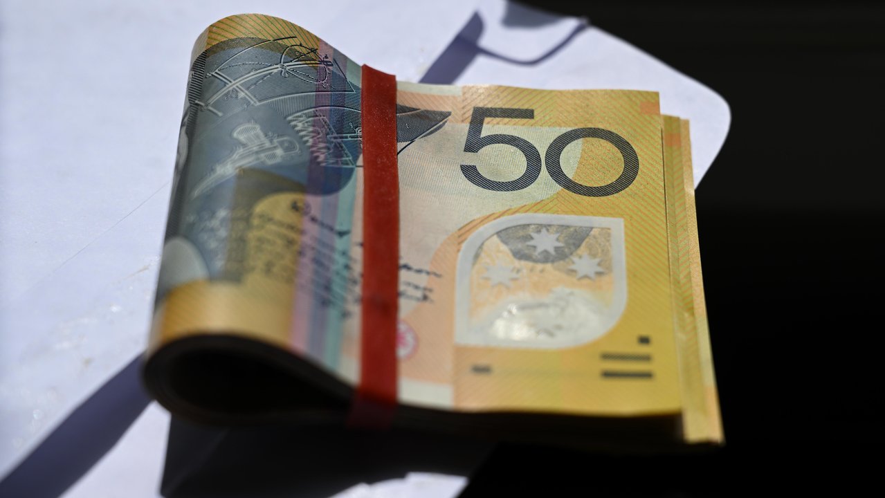 Australian $50 notes sitting on a white envelope