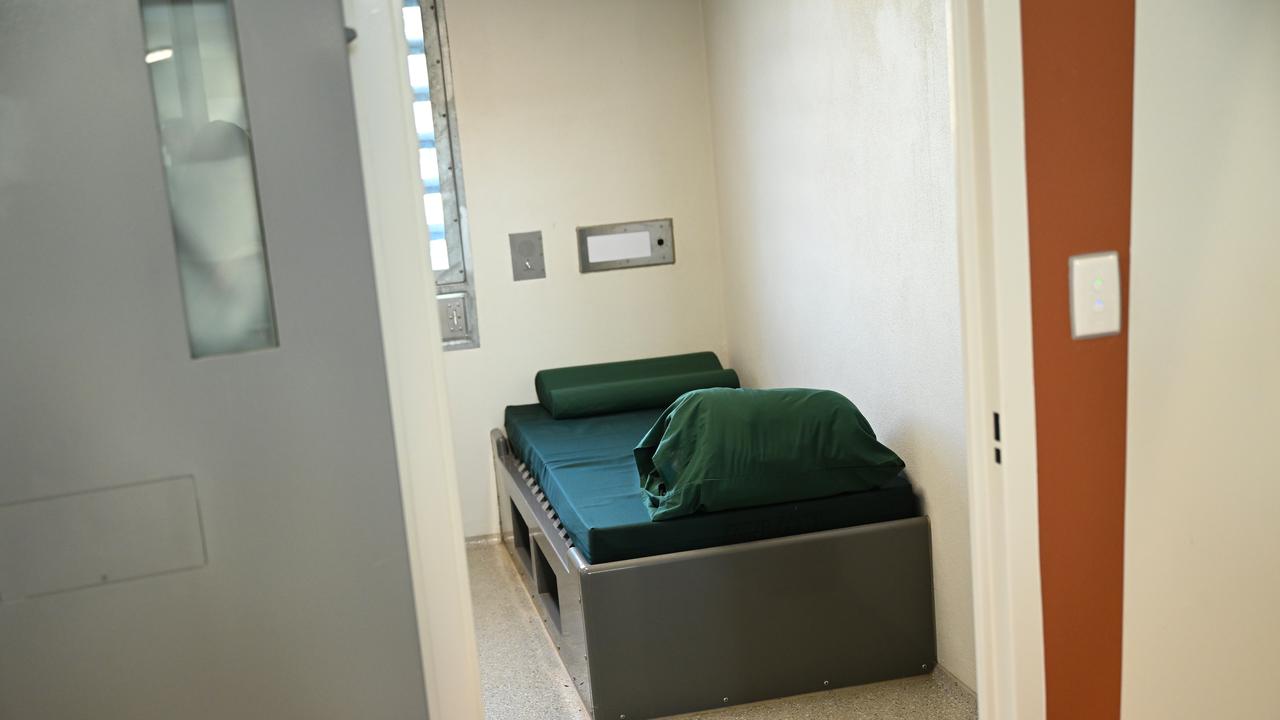 A bed is seen in a prison cell