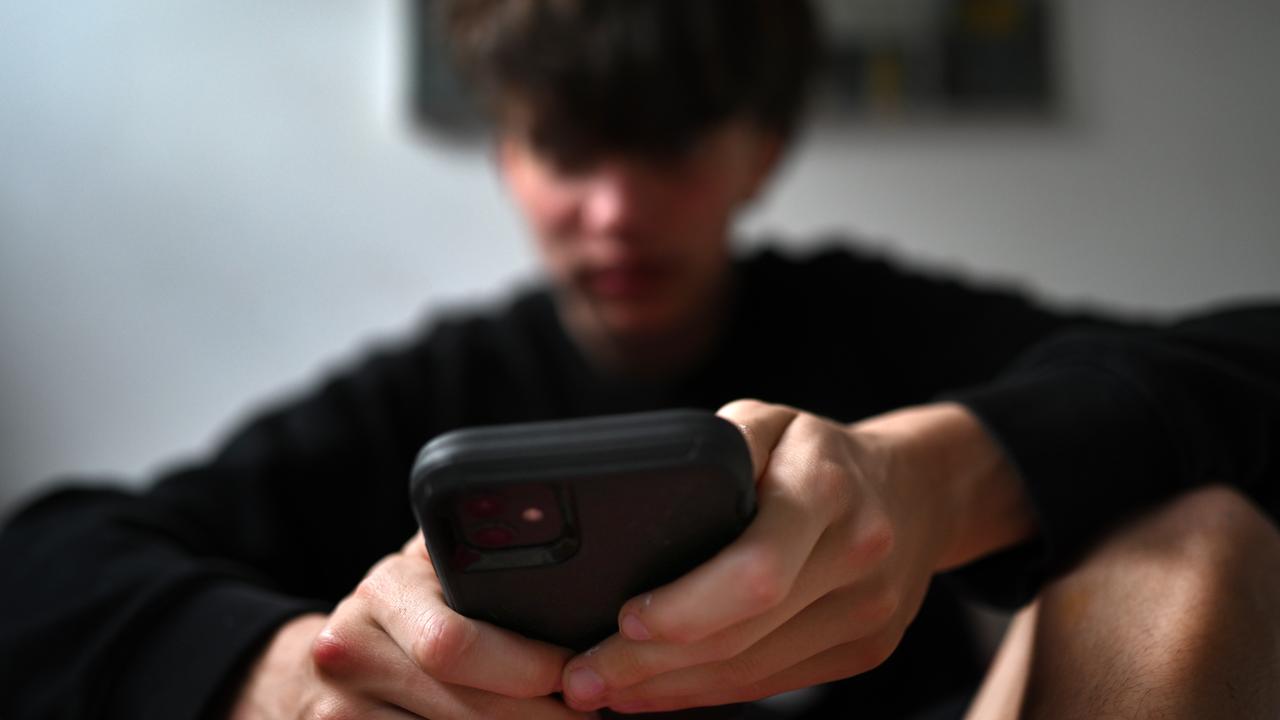 A teenager uses his phone to access social media (file image)