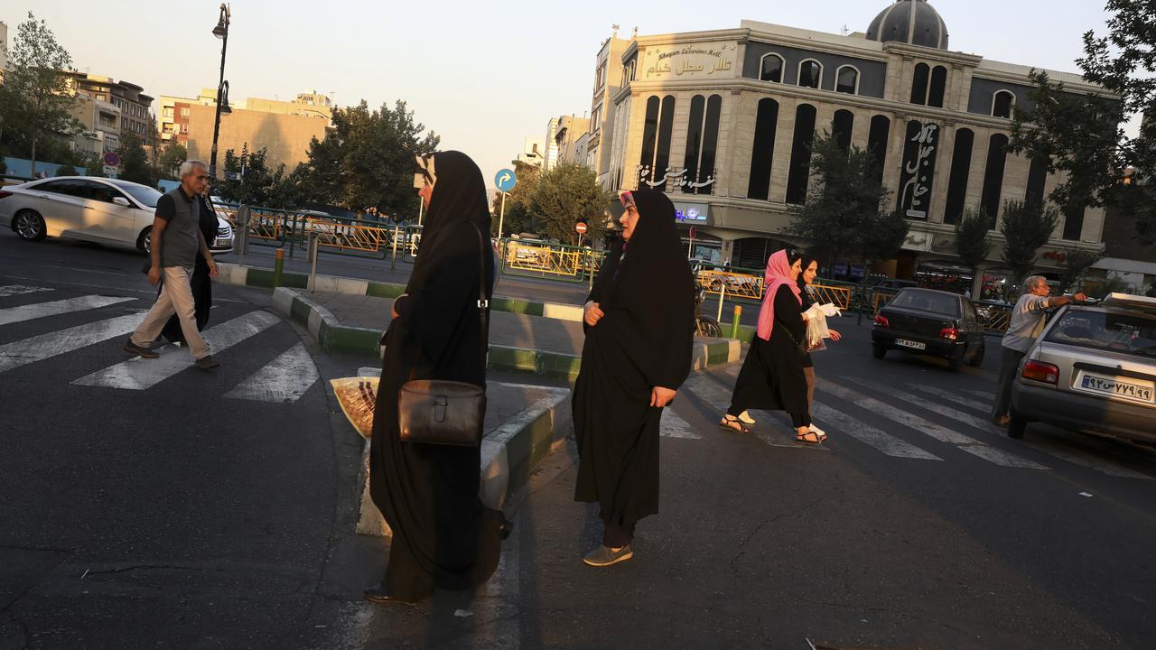 Pedestrians cross a street in eastern Tehran, Iran