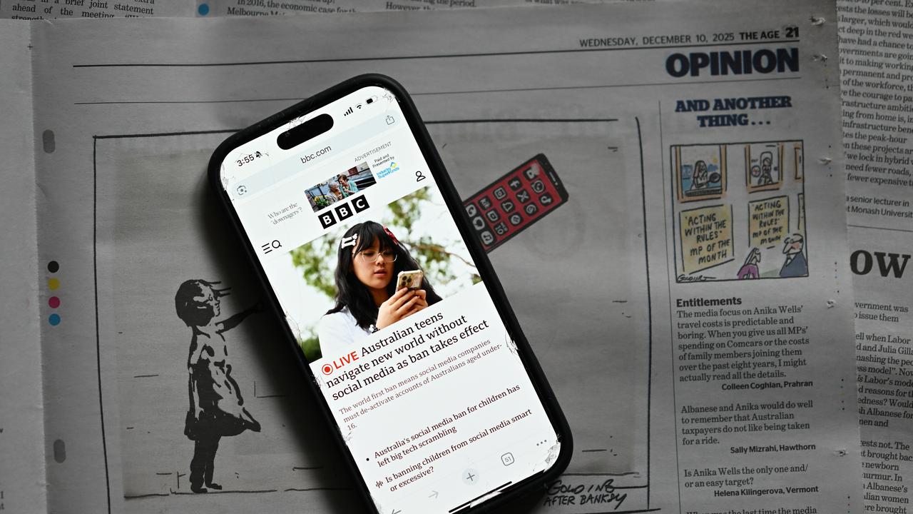 An phone displaying the BBC's homepage on top of The Age newspaper