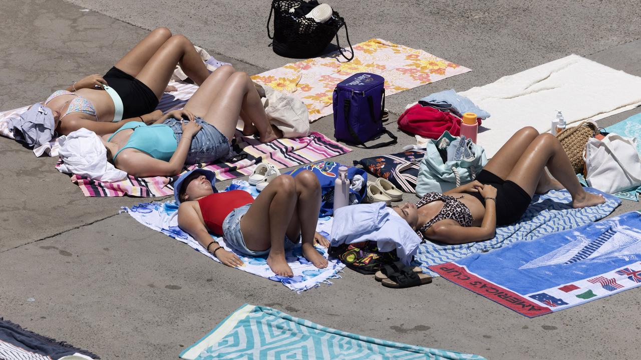 People sun themselves on the concert at Clovelly Beach, Sydney