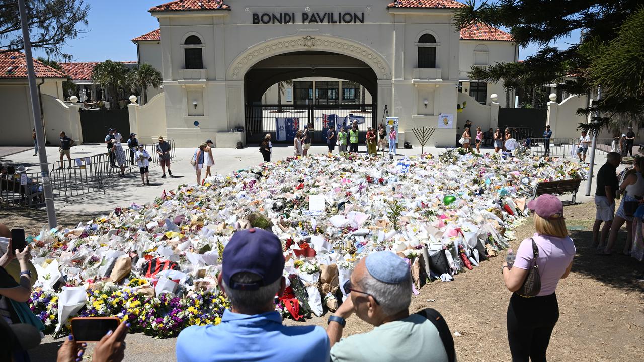 People take photos of a makeshift memorial at Bondi Beach in Sydney