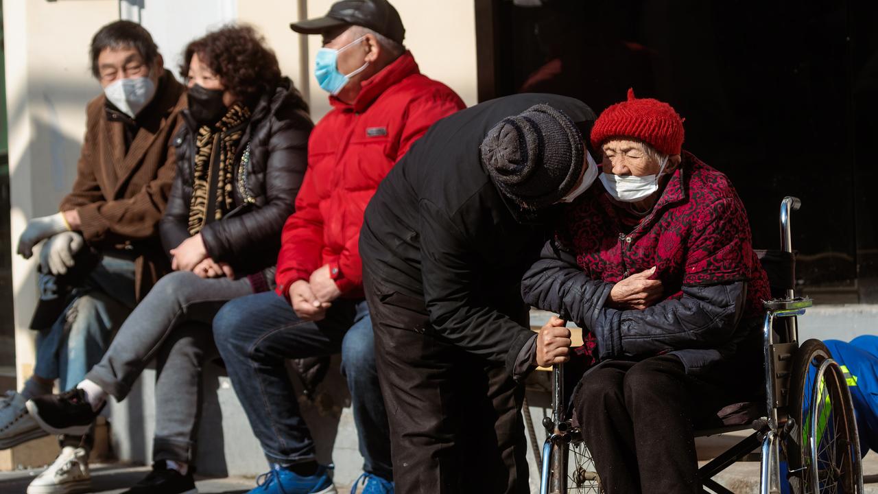 Elder people seated to enjoy the sun on the street, in Shanghai, China