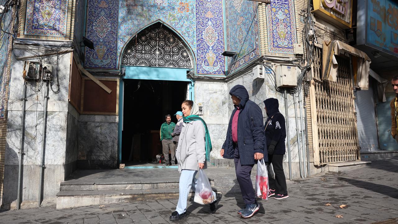 Locals passing by a mosque in Tehran