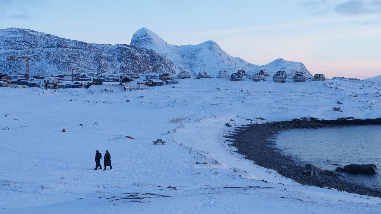 People walk on a beach in Nuuk, Greenland