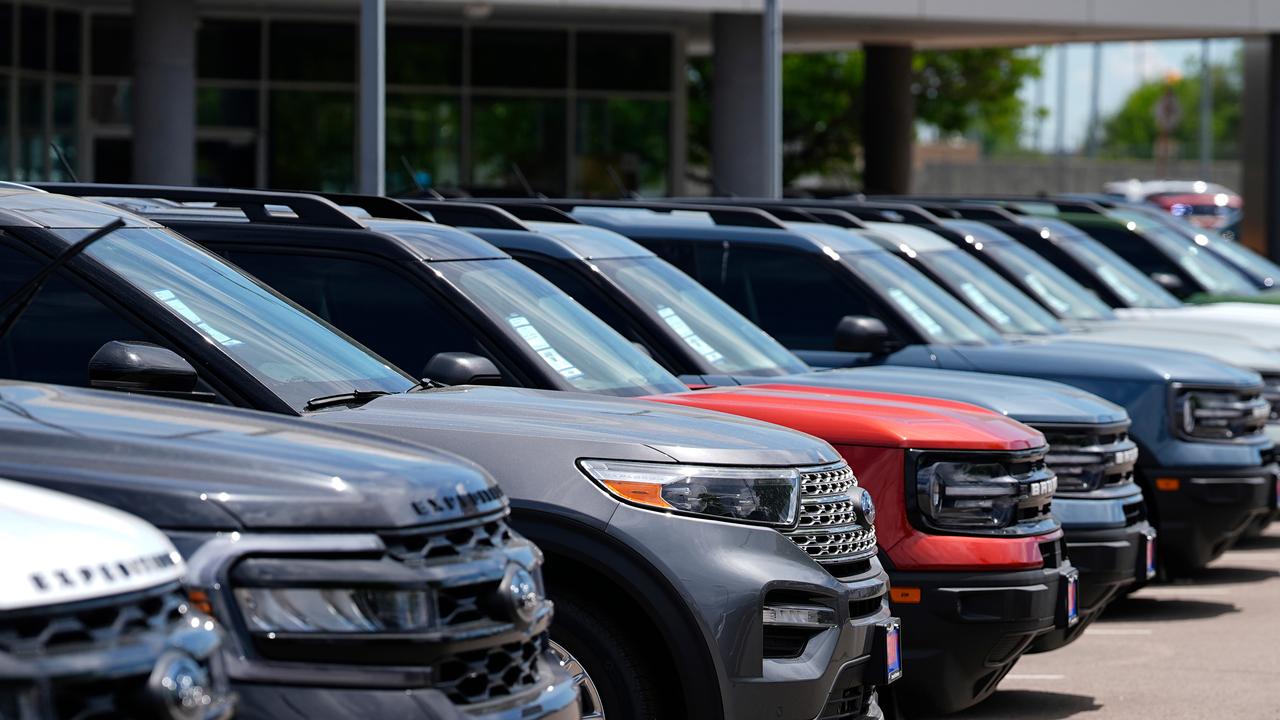 A line of unsold 2024 utility vehicles sit at a Ford dealership
