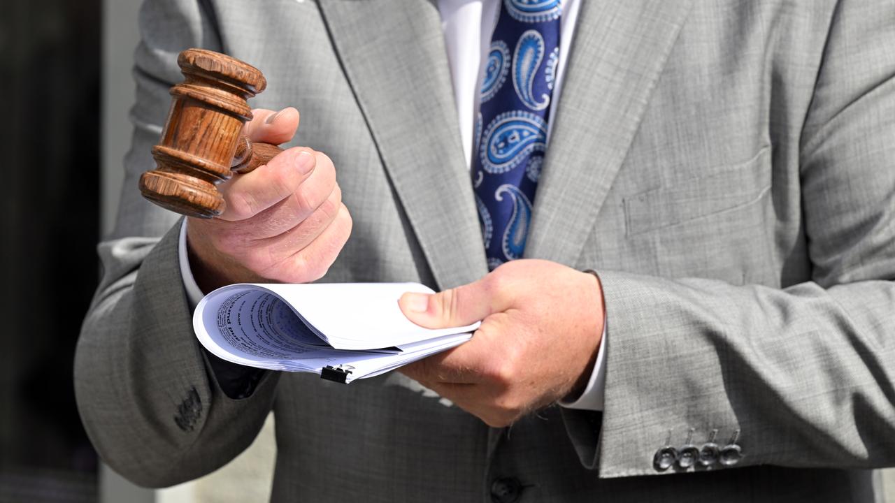 A gavel is held by an auctioneer
