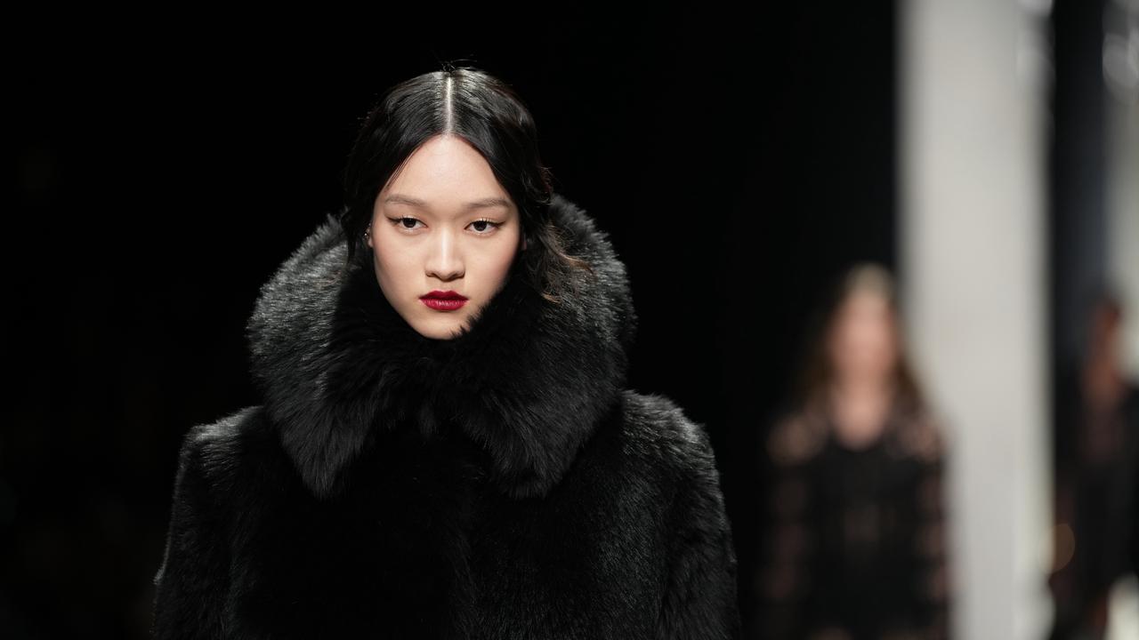 A model wearing a faux fur black jacket