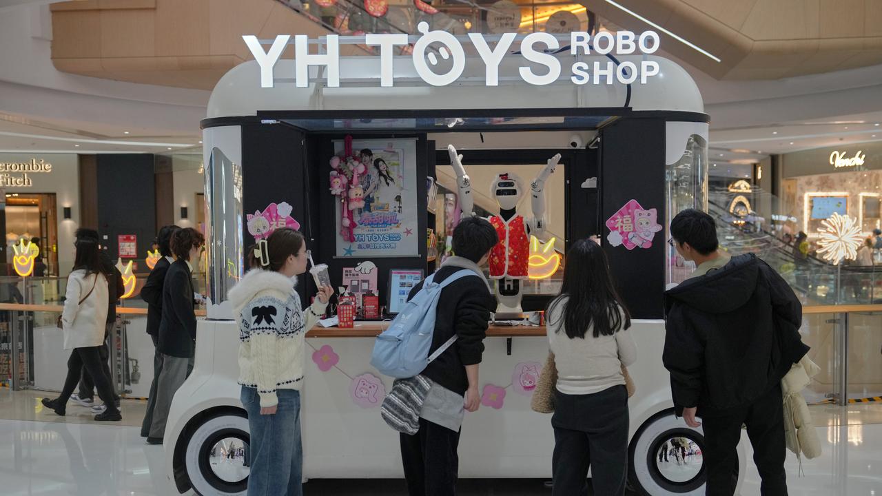 Shoppers look at a humanoid robot (file image)
