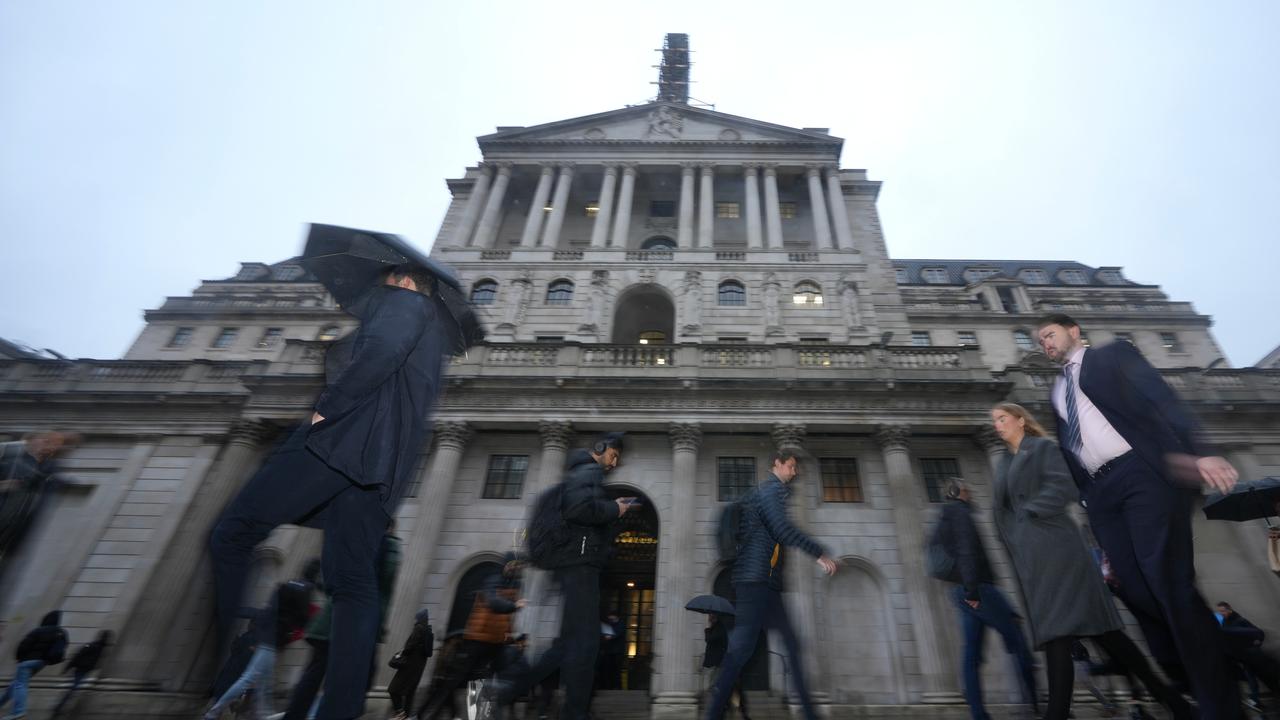 People walk in front of the Bank of England in London