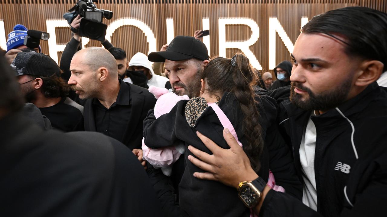 Supporters of family members crowd as they arrive at Melbourne airport