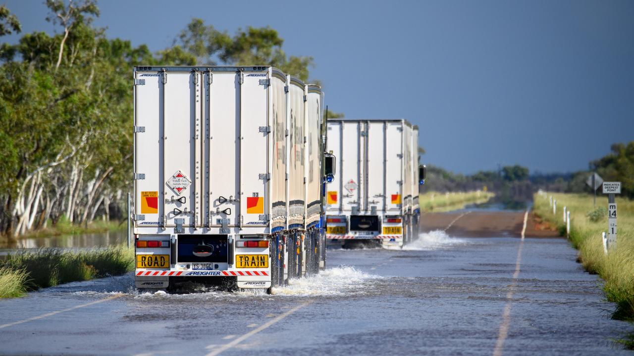 Trucks drive through floods
