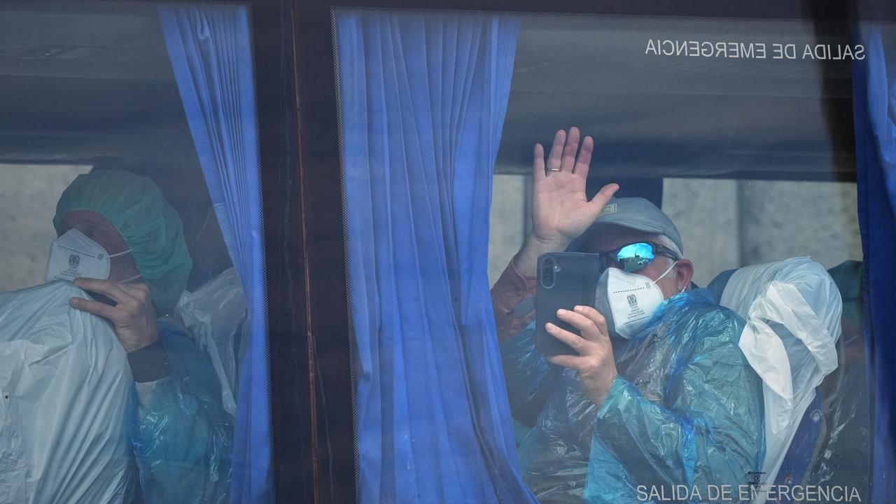 A passenger waves after disembarking from a hantavirus-stricken ship