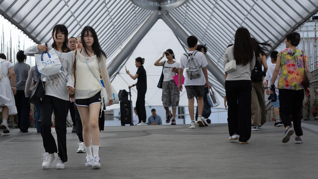People walk in a shopping area in Beijing