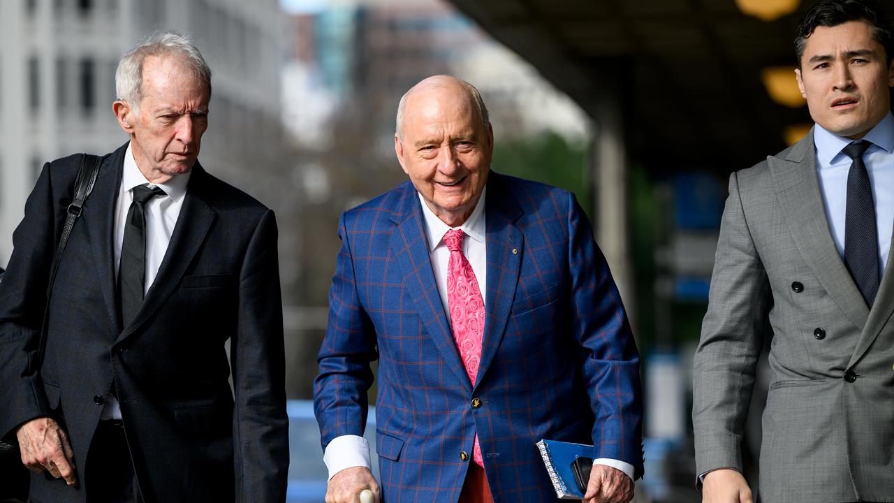 Alan Jones flanked by lawyers