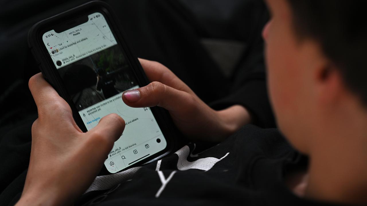 A teenager uses his mobile phone to access social media