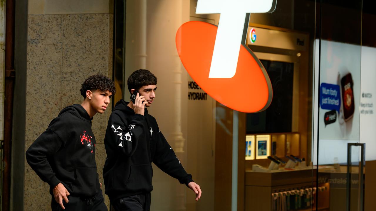 People walk past a Telstra store in Sydney,