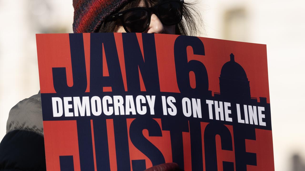 Someone holds a sign calling for justice over the Capitol Hill attack