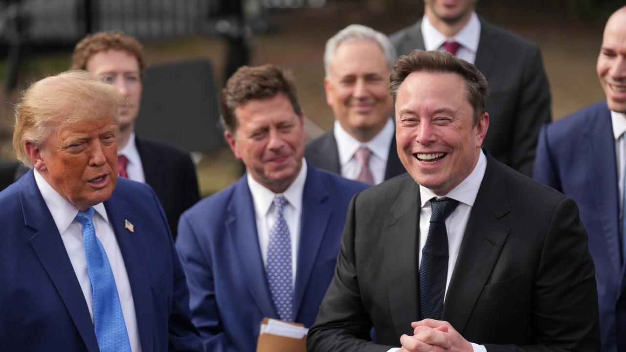President Donald Trump listens as Elon Musk speaks