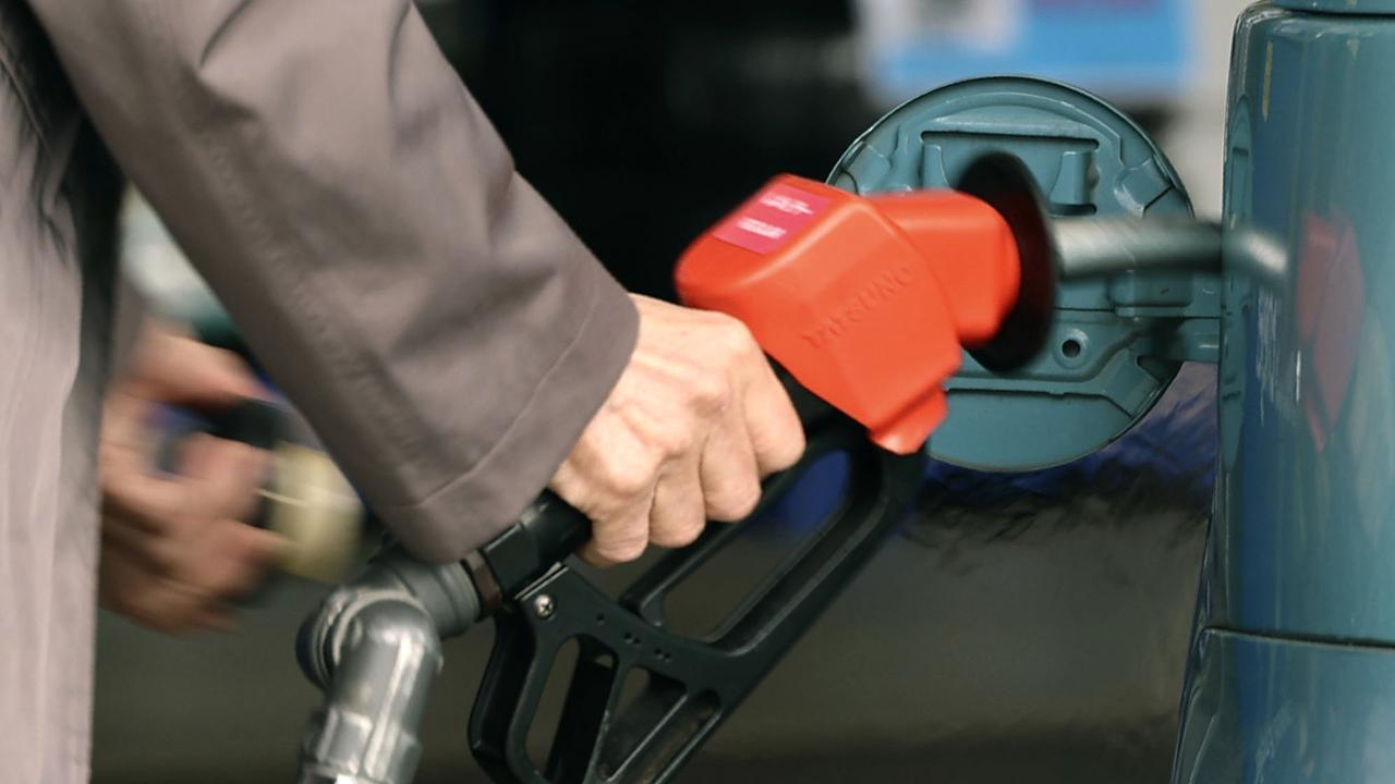 A customer fills up the tank at a service station in Tokyo