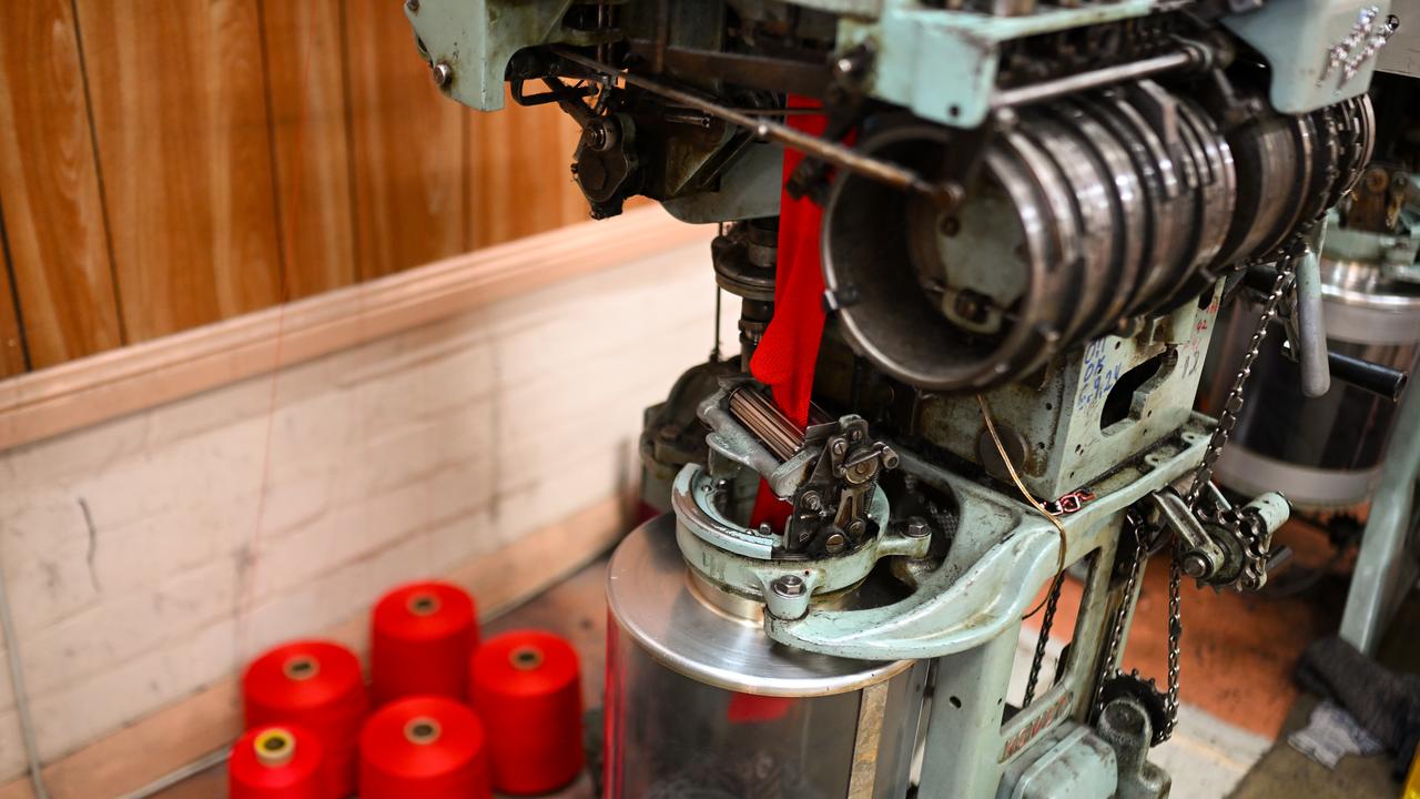 A sock is being produced with a sock knitting machine