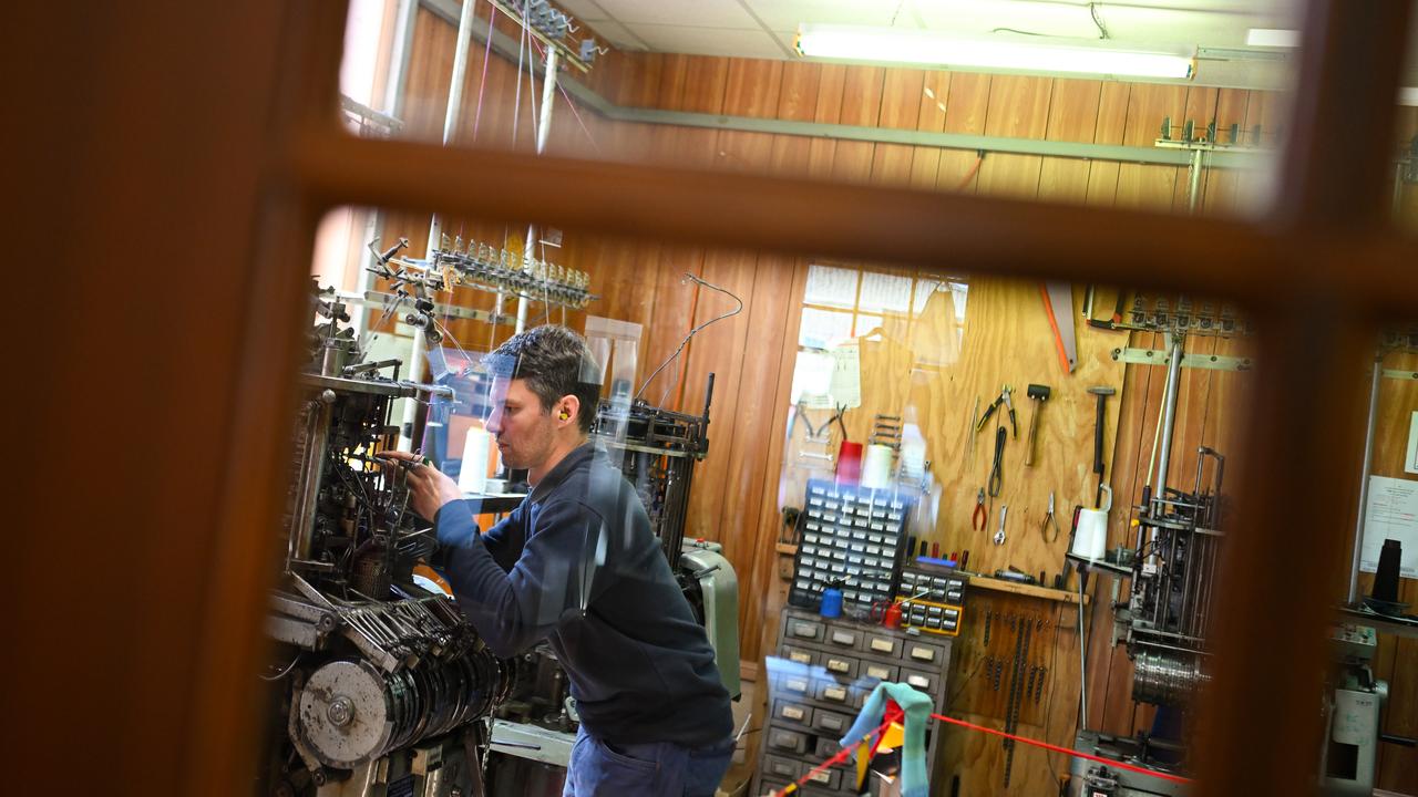 Andrew Lindner services a sock knitting machine