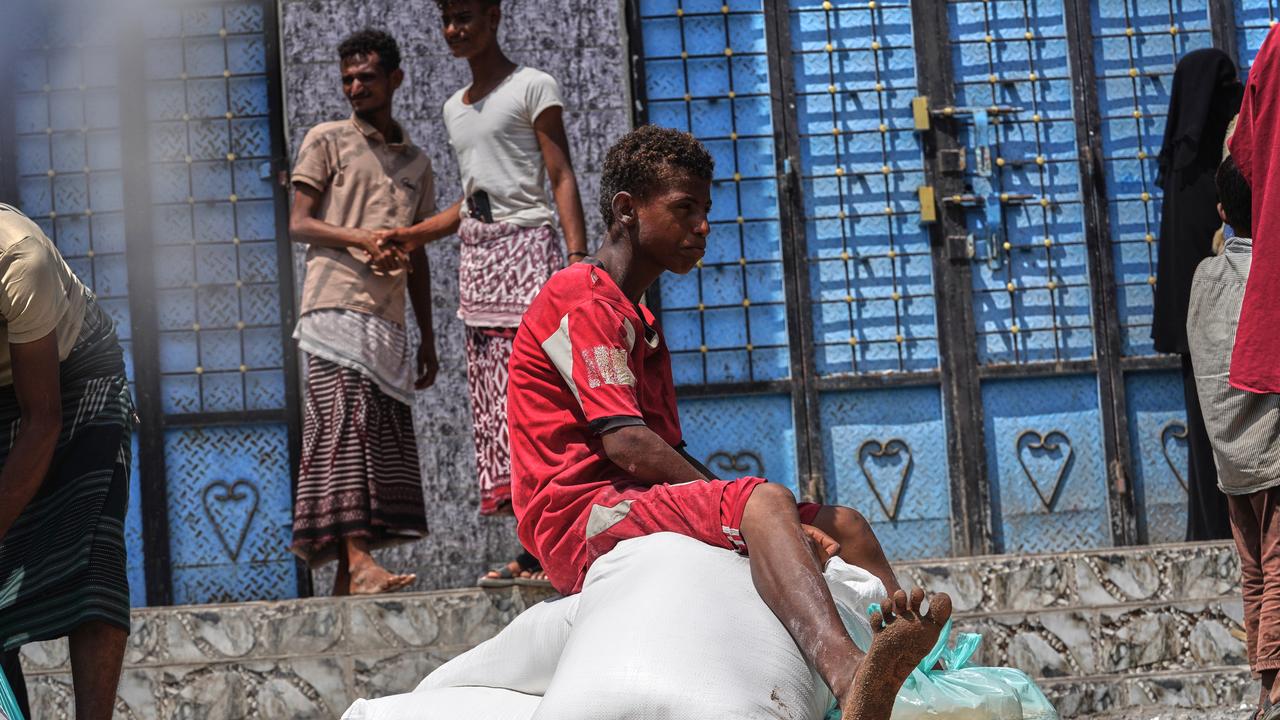 A man sits on sacks of food aid
